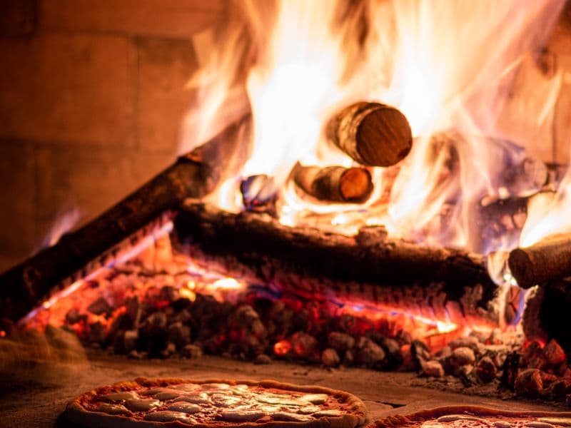 Pizzas en el horno de leña de una pizzería