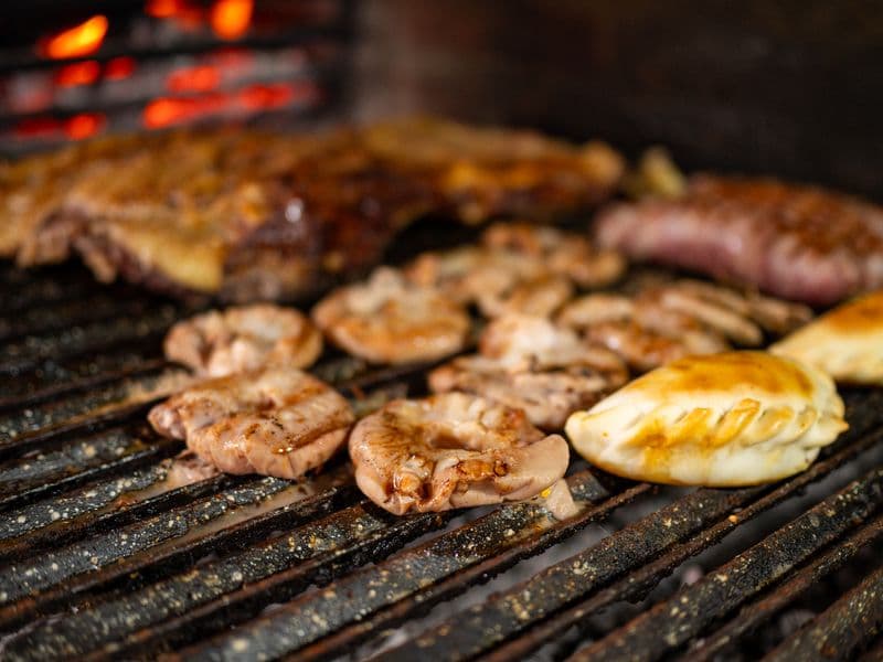 Pollos y milanesas sobre la parrilla de una rotisería